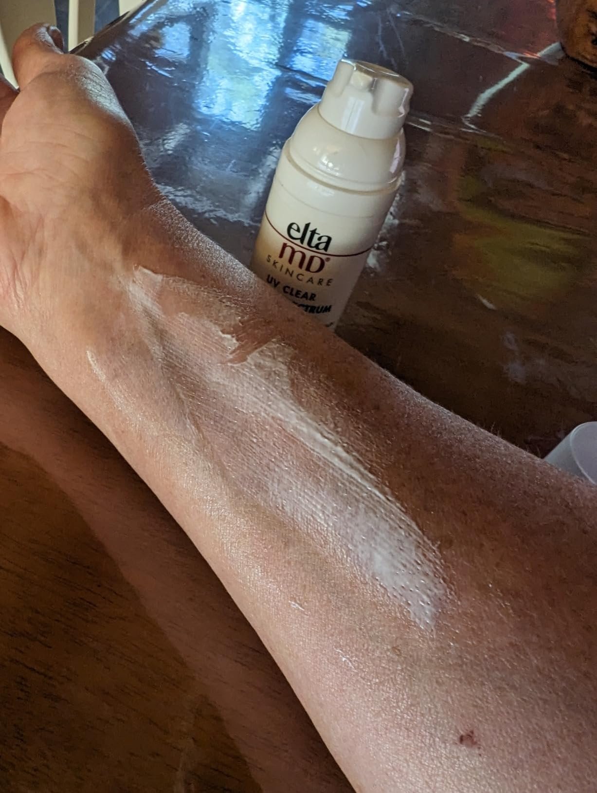 Supplied image showing EltaMD UV Clear sunscreen spread over an arm