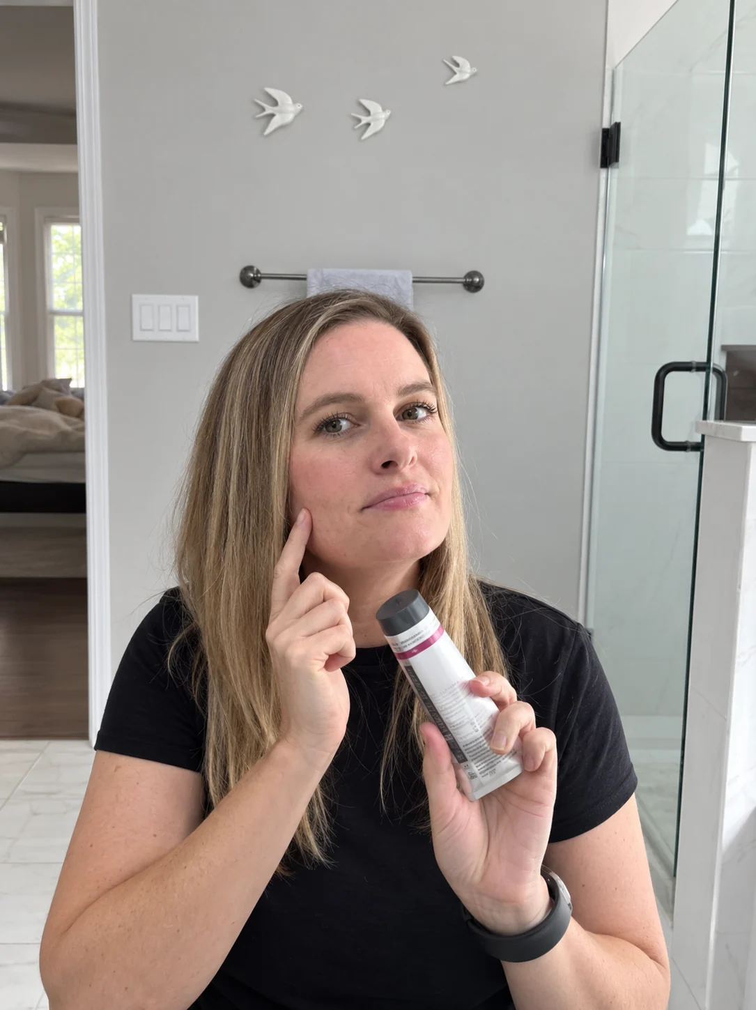 Customer holding a skincare tube beside her face