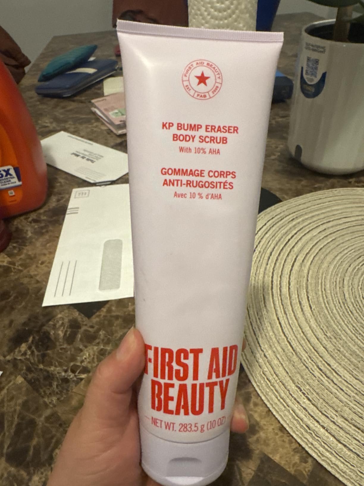 First Aid Beauty KP Bump Eraser Body Scrub 10% AHA tube held in hand