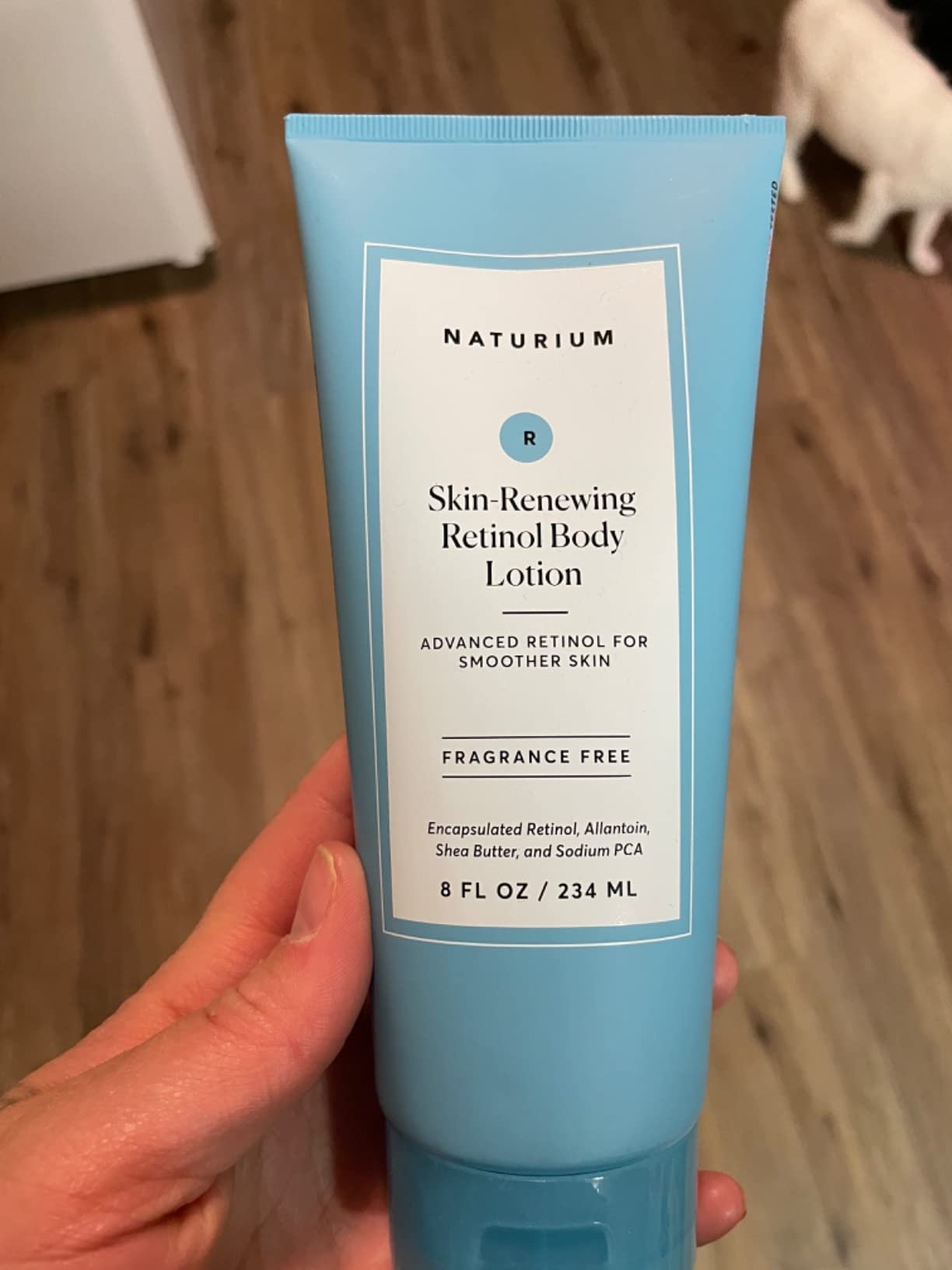 Naturium Skin-Renewing Retinol Body Lotion tube held in hand