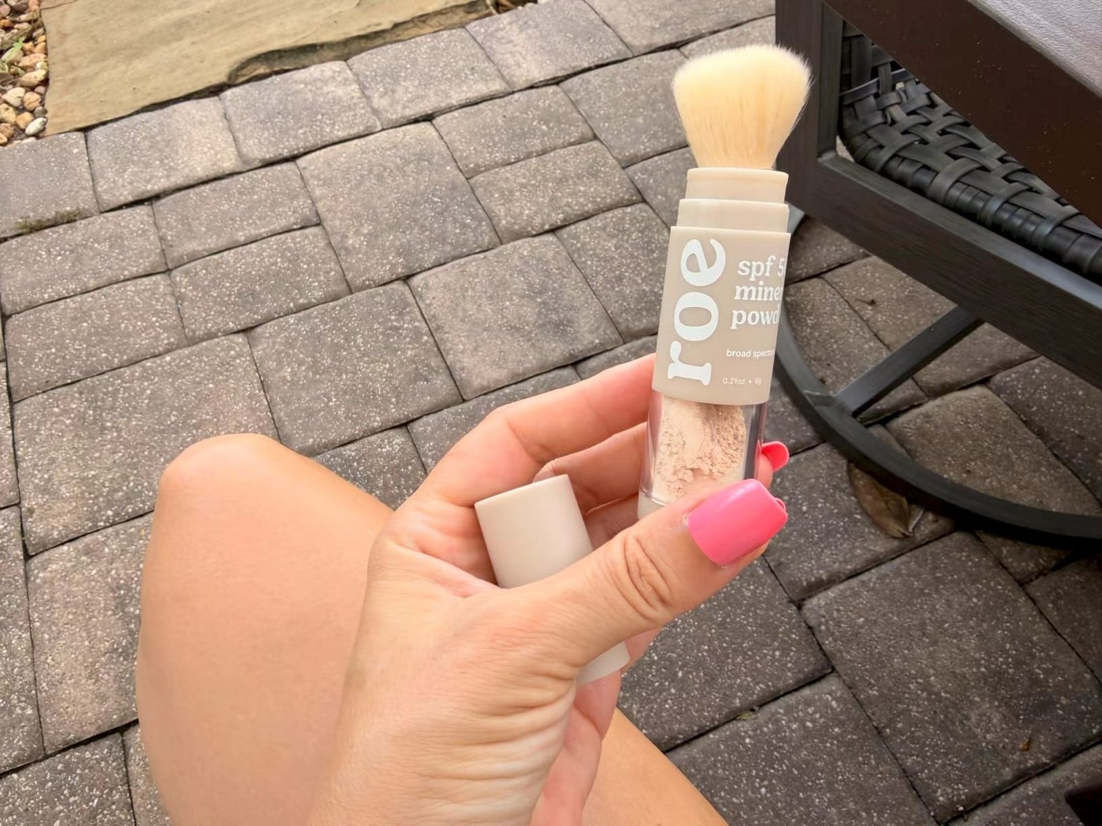 roe Wellness SPF 50 Mineral Powder brush held outdoors